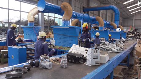 Workers sort e-waste using a system of conveyor belts across Enviroserve&#39;s recycling facility near Kigali.